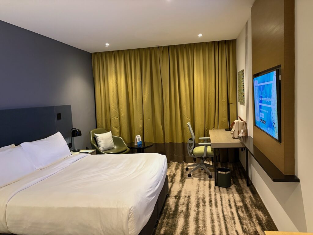 King bed and work desk setup in a standard room at Hilton Garden Inn Bangalore.