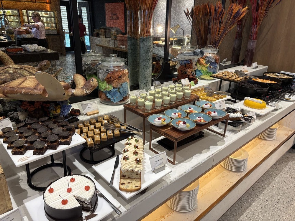 Extensive pastry and cake dessert buffet counter display at Cosmo restaurant