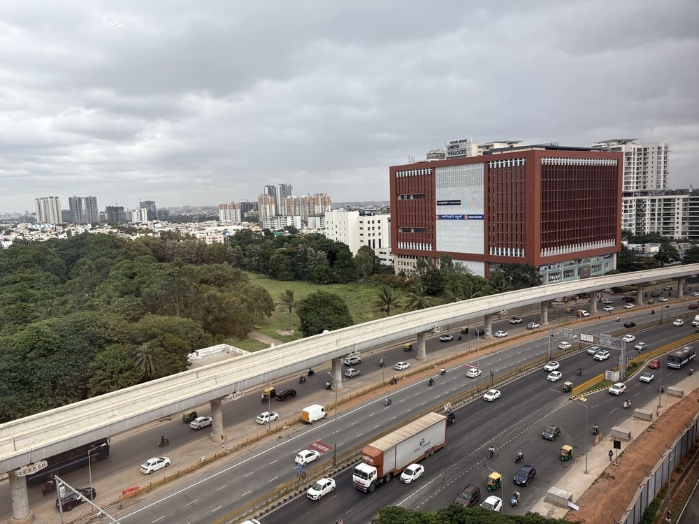 Elevated 9th floor window view of road traffic and Hebbal lake landscape layout from the hotel room