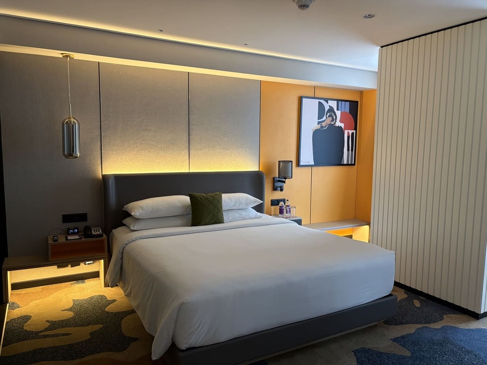 Large luxury suite king bedroom layout with modern lighting accents